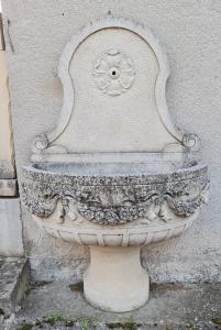 Brunnen aus weißem Stein mit Giebel